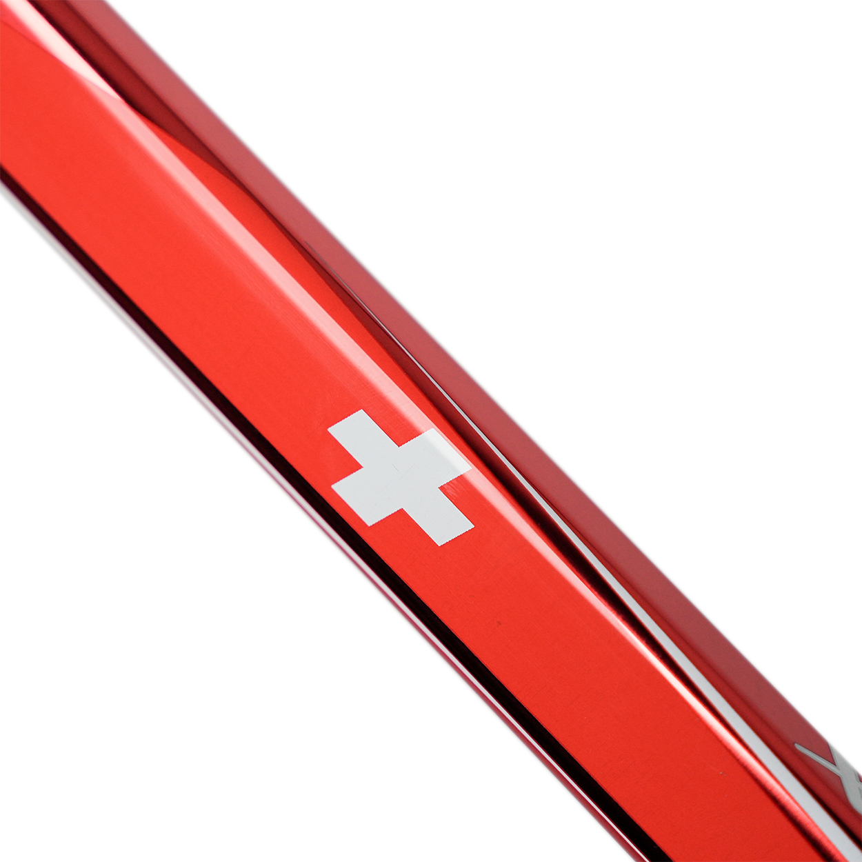 Close-up of a red metal object with a white cross emblem on a white background